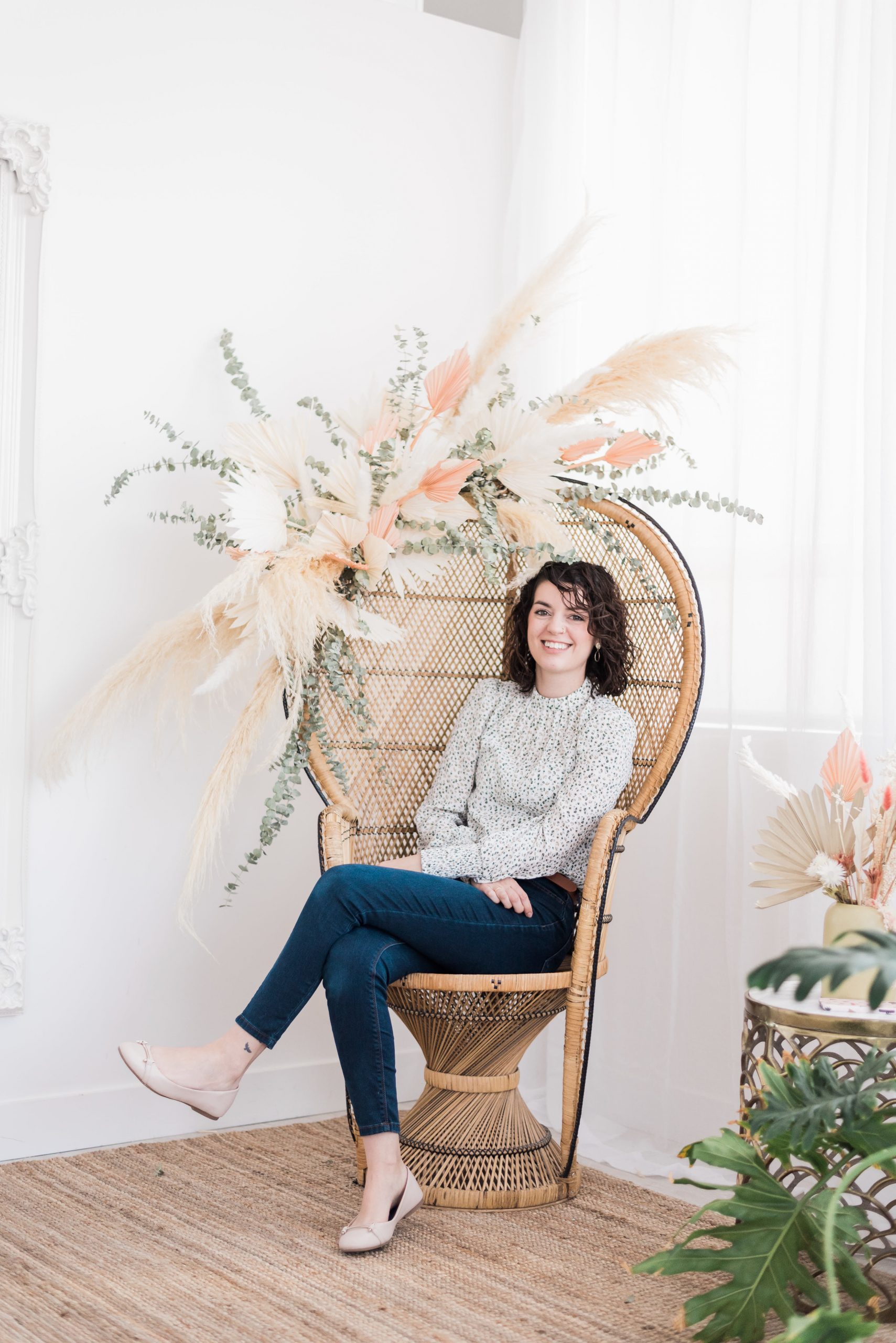 Girl sitting in wicker chair with flowers attached