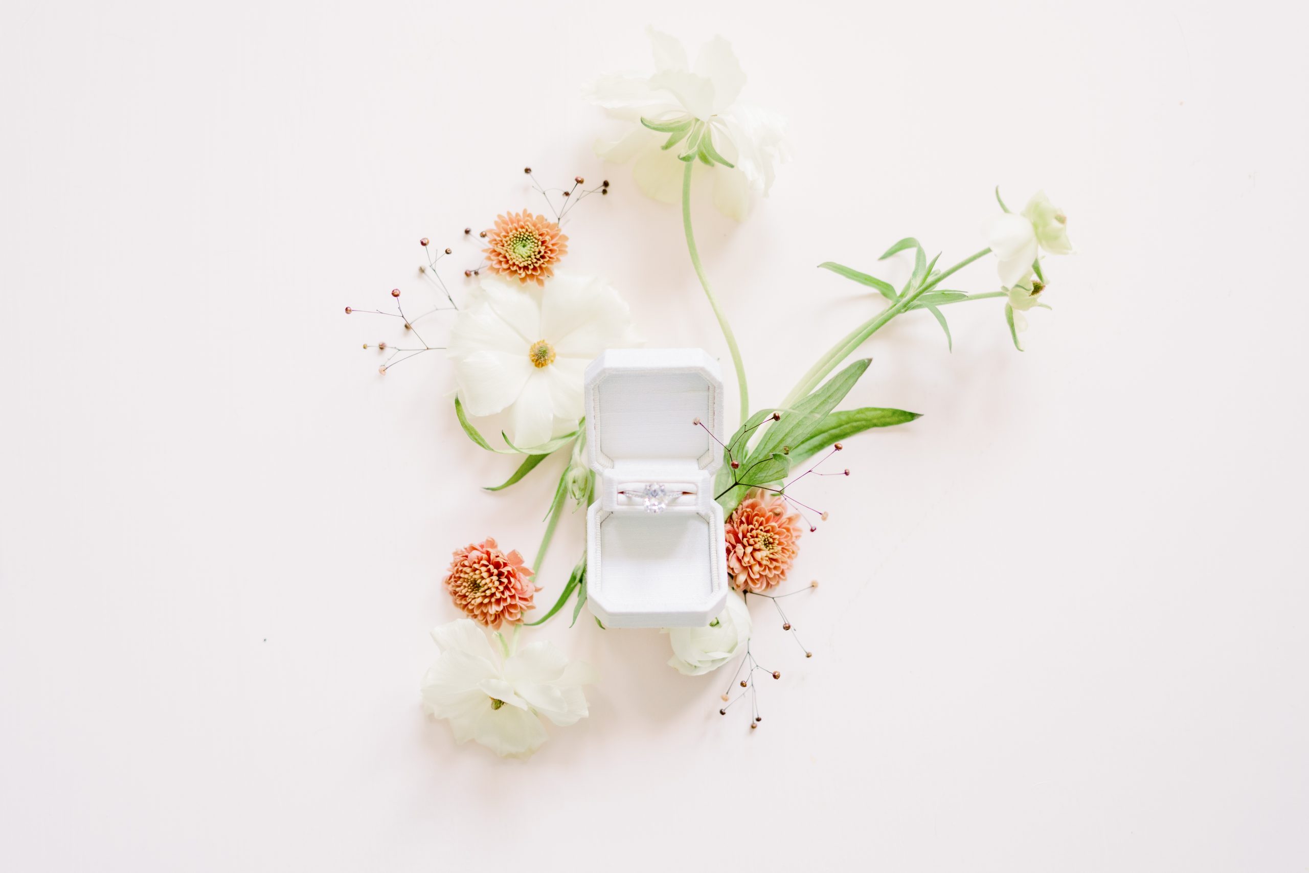 engagement ring in box and surrounded by flowers